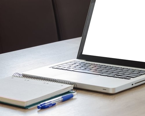 Desk setup with a laptop and a notebook