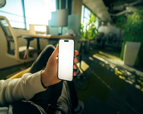 Person holding a smartphone in a modern office