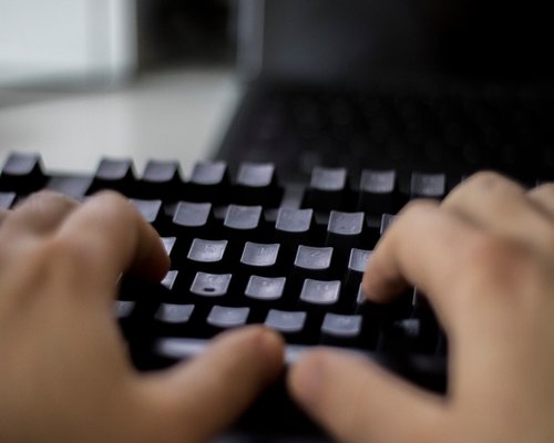 Hands typing on a computer keyboard