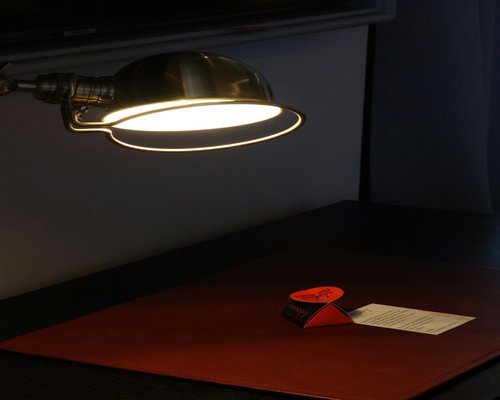 Close up of a desk lamp illuminating documents
